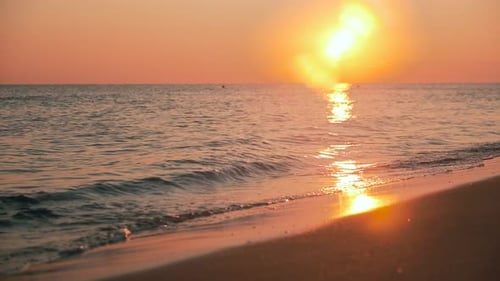 Sanfte Wellen bei Sonnenuntergang am Strand