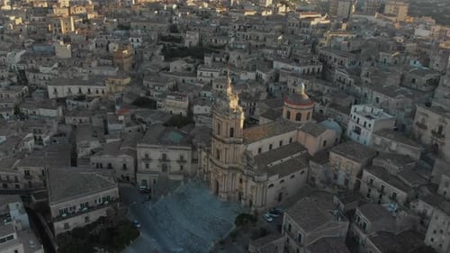 Aerial view of historic town and cathedral at sunrise, Italy.