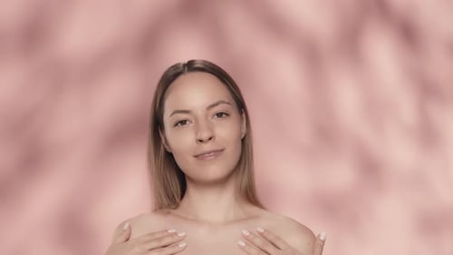Woman Gently Massaging Face and Neck in Studio
