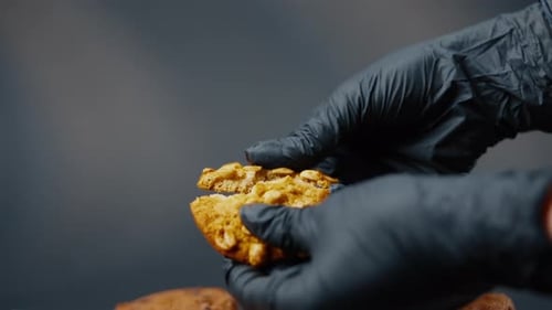 Close Up on a Black and Blue Background Flat Plate with Cookie Cookies Built in a Pyramid a Female
