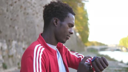 Young Adult Using Smartwatch Outdoors in City