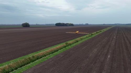 Tractor Spraying Pesticides On agricultural field With Sprayer