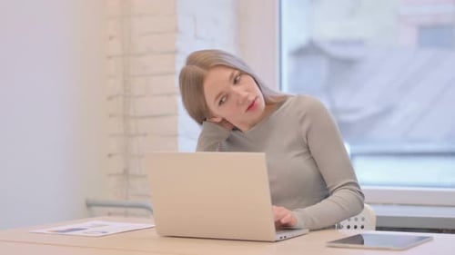 Woman Massaging Stiff Neck at Desk