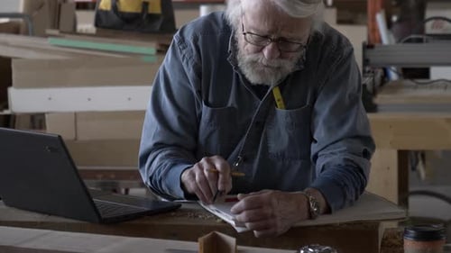 Senior Man Working on Plans in Workshop