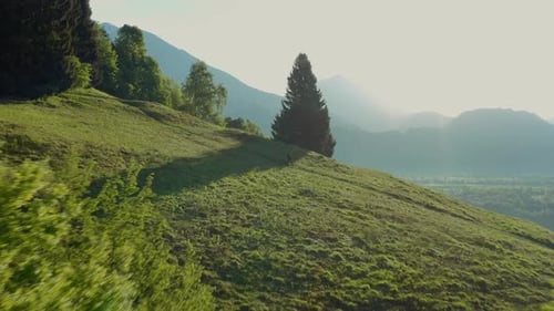 Amazing aerial view a young athletic man on an e-bike pedaling up the hill with a beautiful view.