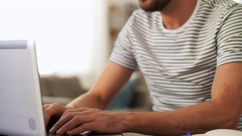 Man Working on Laptop Computer with Headphones On
