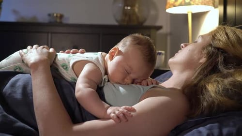 Woman Lying in Bed with Sleeping Infant