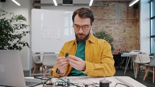Engineer Working with Electronics and Stretching in Office
