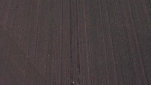 Tractor tyre tread print pattern aerial view in countryside fertile ploughed farmland field rising t