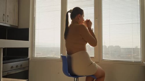Woman Drinking Coffee By Window in Morning Sunlight