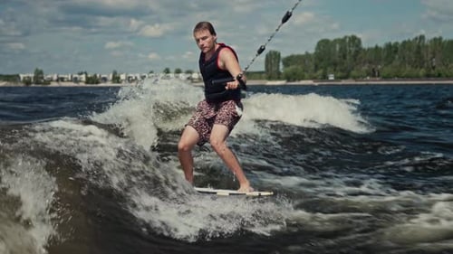 A Young but Experienced Wakesurfer Glides Along the Wave A Man Rides a Boat on the River Summer