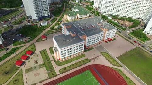 Aerial view football field on sport ground in schoolyard with high rise buildings