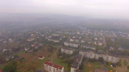 Fog covered usual big city with residential areas and stadium.