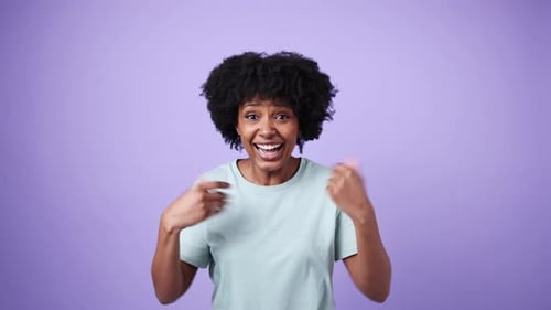 Excited woman reacting to good news against purple background