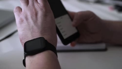 Close Up of Smartphone and Smart Watch Use