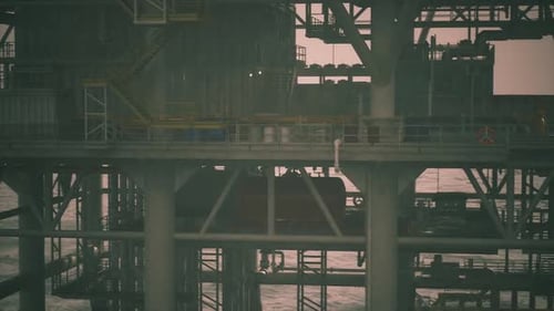 Oil Rig Works Near Coastline During Late Afternoon Light Conditions