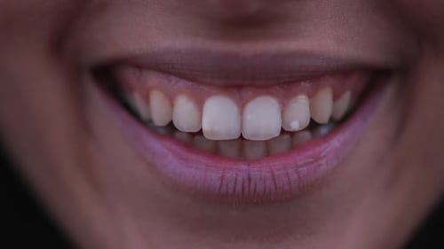 Macro closeup female mouth and lips smiling at camera. Extreme close up body detaul smile. Adult