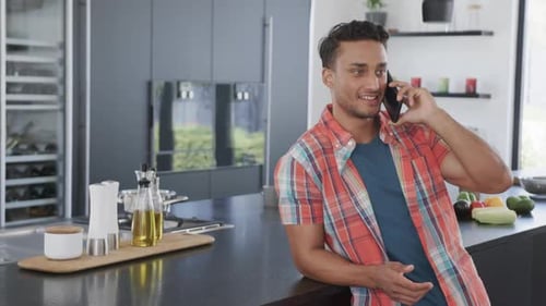 Young Man Talking on Phone in Modern Kitchen