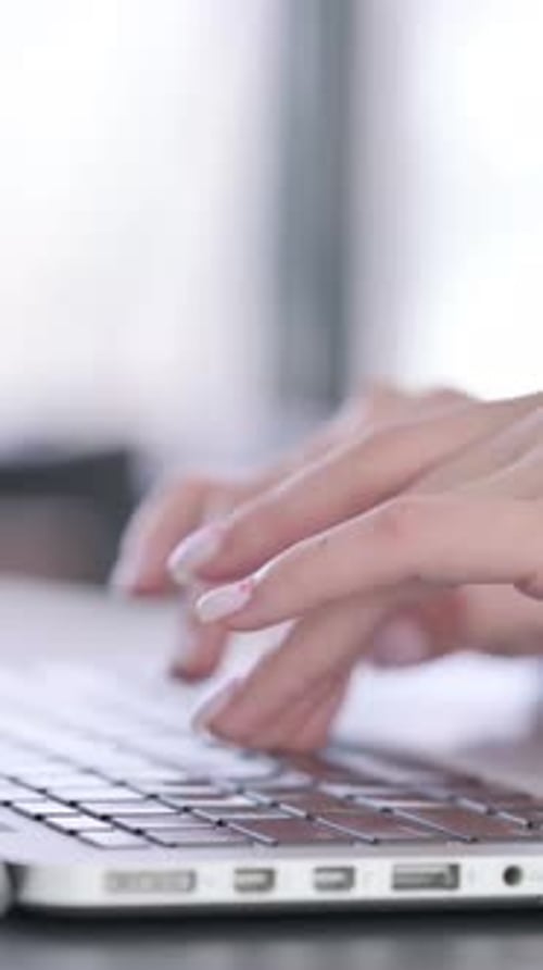 Close up of Hands of Female Typing on Laptop Keyboard, vertical video