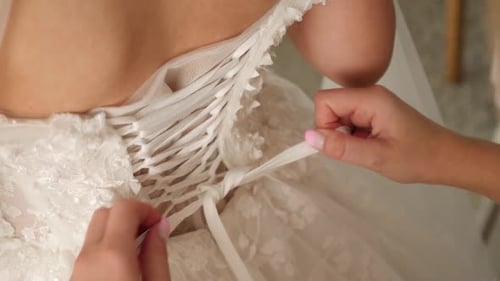 S25. Dressing the bride's dress. The girl ties a knot on the dress