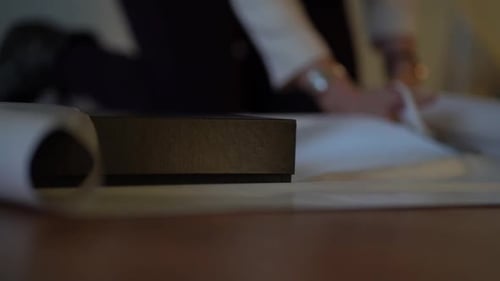 Plans Being Unrolled on Workplace Table