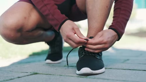 Person Tying Their Athletic Shoes Outdoors