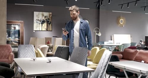 Man Wearing Eans Shirt Walking Standing in Furniture Store Buying Table Finding