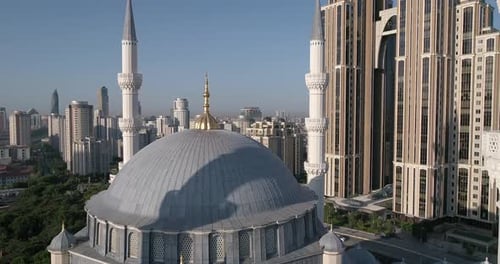 Aerial video flies forward above, crossing between two minarets on a mosque in Istanbul