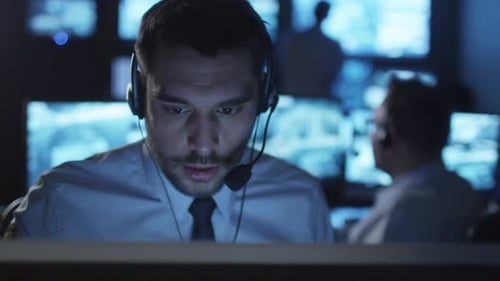 Man Speaking into Headset in Dark Office at Night