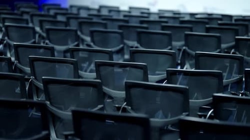 Empty Rows of Modern Black Mesh Conference Chairs Fill a Large Auditorium Chrome Frames Reflecting