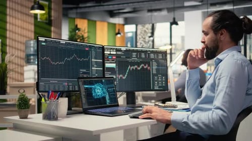 Bearded Man Typing at Computer Analyzing Financial Data