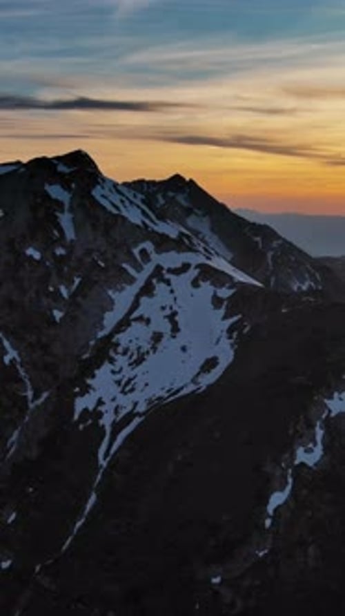Rocky snow mountains and sunset sun