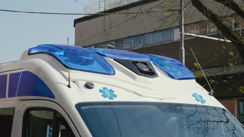 Blue flashing siren on roof of ambulance car