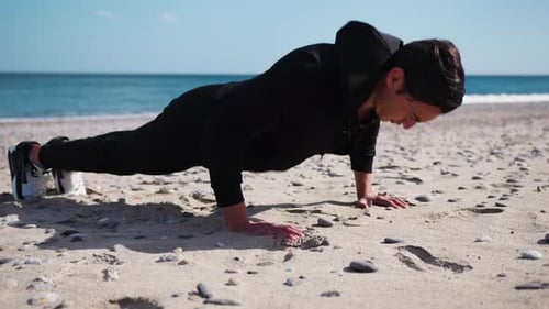 Boy Does Push Up Exercises In Outdoor Gym On The Beach Near The Sea