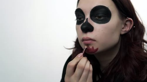 Young Adult Applying Skull Makeup Close Up