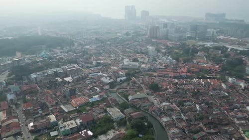 A city with a river running through it. Aerial misty view Melaka