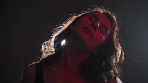 Woman with Wavy Hair Posing in Dramatic Lighting