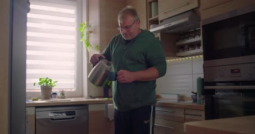 Man Pours a Drink in a Modern Kitchen