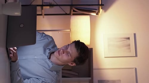 Young Adult Typing on Laptop at Night