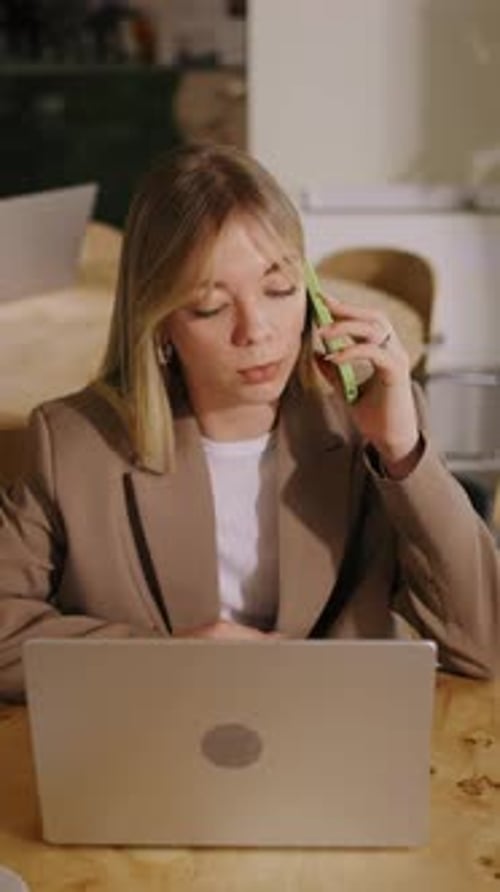 Woman working with laptop in office and talking