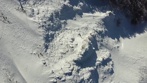 Aerial top down of winter snow covered mountains landscape with pine tree forest hiking trail reach