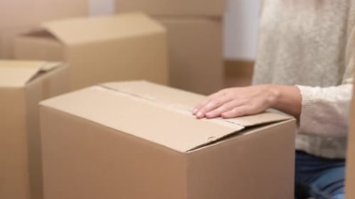 Woman Taping Moving Box for Storage