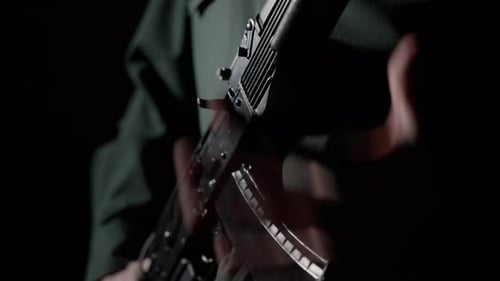 Person Holding an Assault Rifle in the Dark