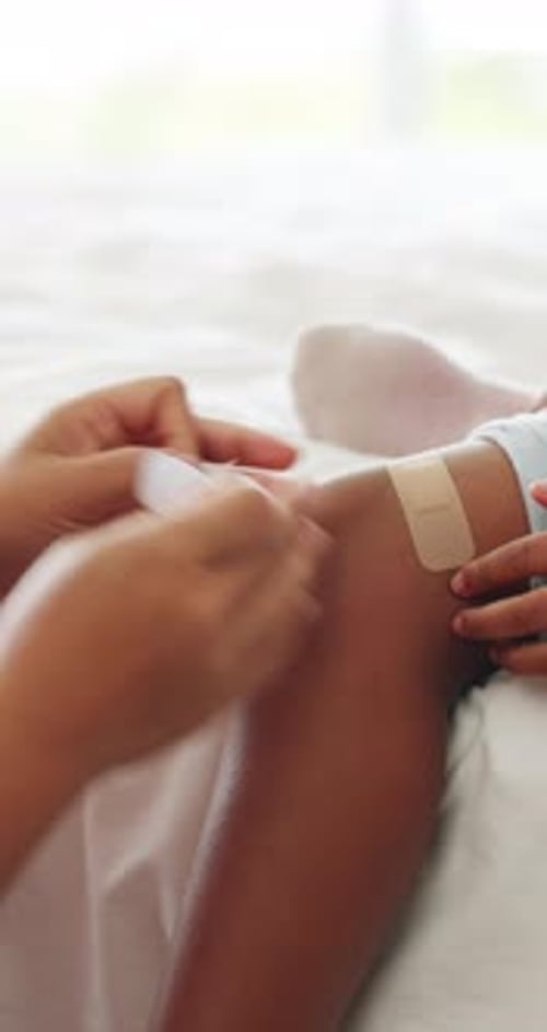 Injury, child and hands of mother with plaster on bed for first aid, healing or wound care for knee