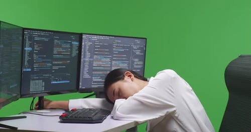 Tired Asian Woman Developer Sleeping While Write Code With Multiple Screens In Green Screen Studio