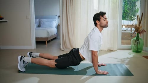 Handsome Athlete Stretching Body Practicing Upward Dog Yoga Pose on Mat