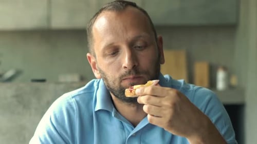 Man Eating Toast with Vegetables at Home