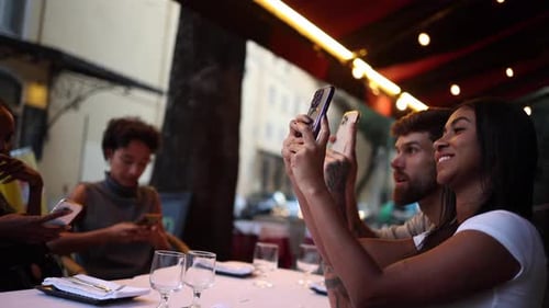 Friends taking pictures at restaurant table