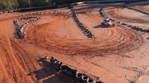 Un buggy de carreras todoterreno maniobra a través de una polvorienta curva en una pista de tierra en Carballo, España. Cámara lenta