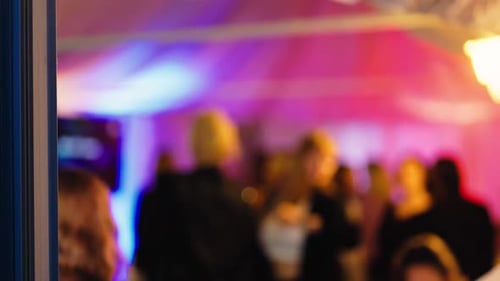 A Vibrant Festival Scene Filled with Colorful Lights Featuring a Blurred Crowd Joyfully Enjoying the